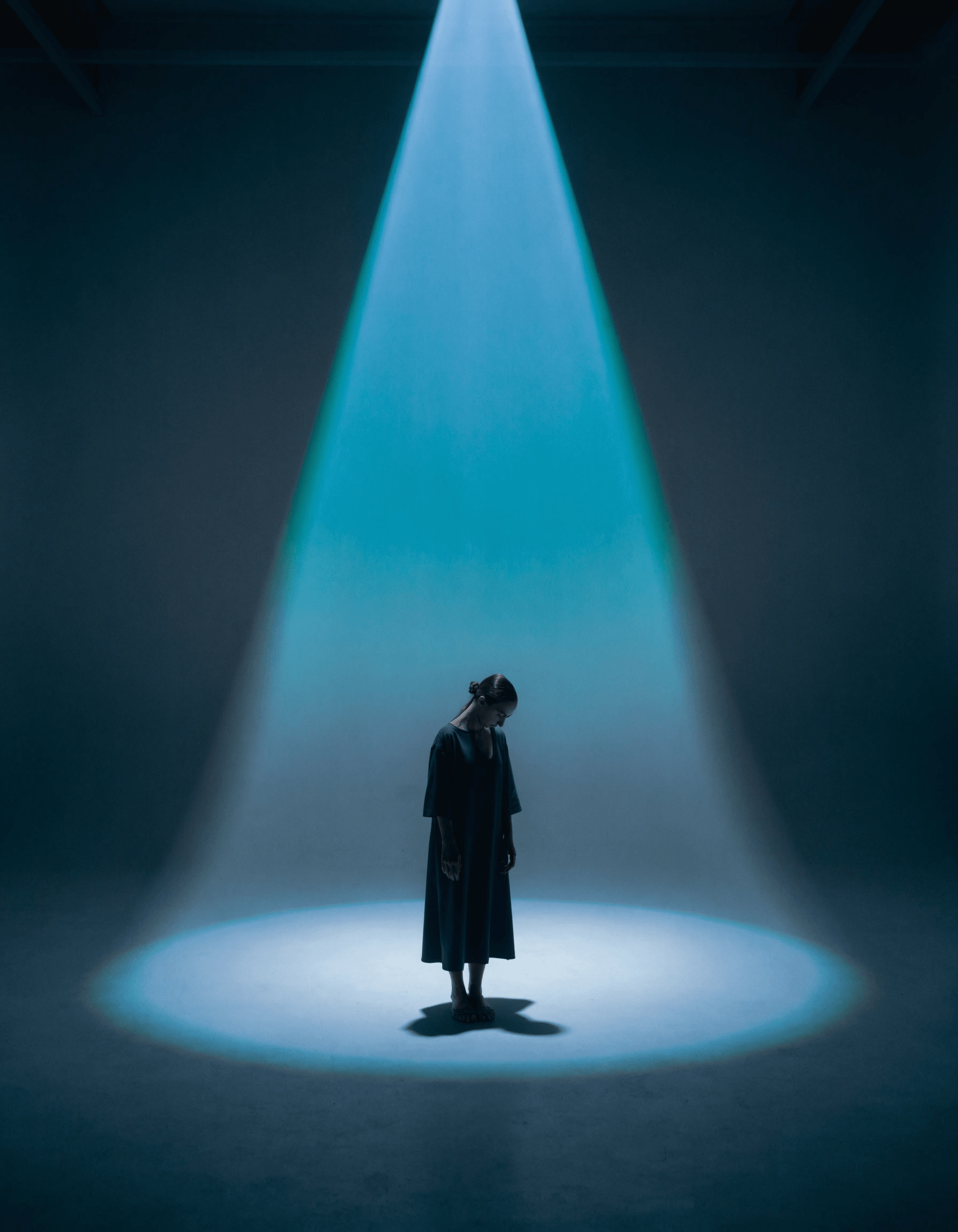 Person standing under a widening beam of light